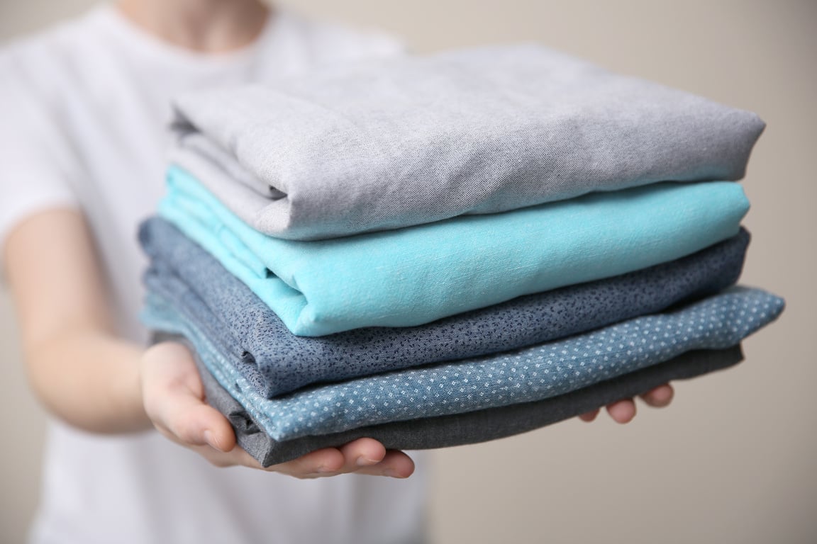 Woman Holding Folded Clothes